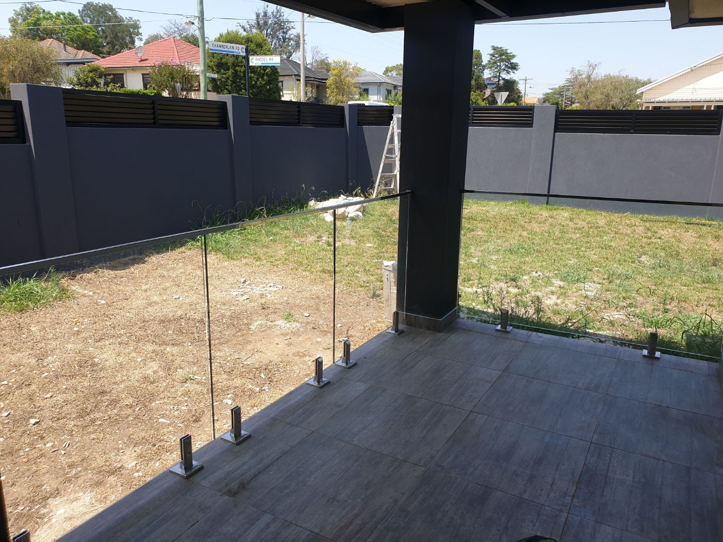 Front Porch glass balustrades with mirror finish stainless U-channel top handrail and spigots.