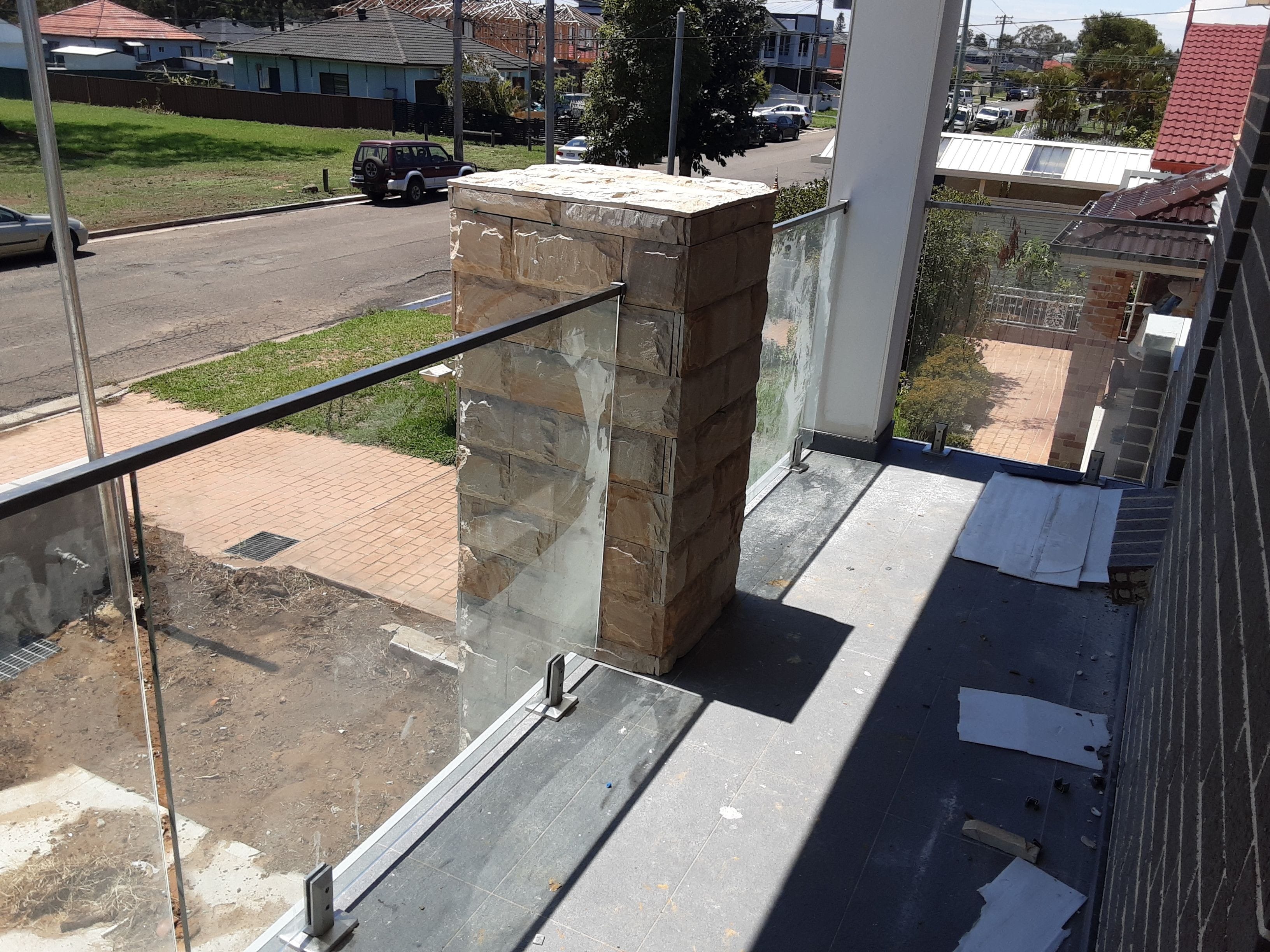 balcony glass and stainless balustrades with satin finish top U-channel handrails and spigots.